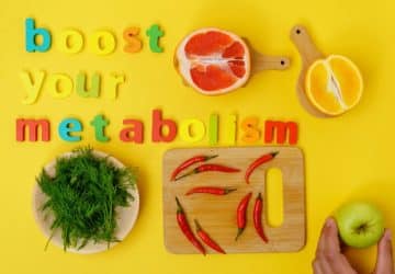 scritta colorata boost your metabolism su sfondo giallo, immagini di frutta verdura intorno; accelerare il metabolismo
