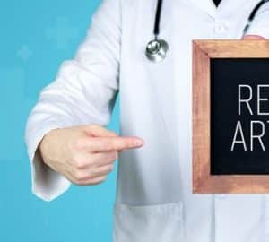 medico con in mano una lavagnetta con su scritto artriti reattive in inglese