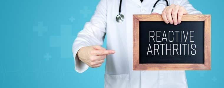 medico con in mano una lavagnetta con su scritto artriti reattive in inglese