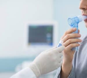 La spirometria aiuta a valutare come lavorano i polmoni: Primo piano di mani che tengono un misuratore di picco di flusso…